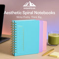 HighPeak Aesthetic Spiral Notebooks in blue, lavender, and pink with gold spiral on desk with pen and laptop