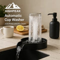 HighPeak Automatic Cup Washer in black with high-pressure 360° rinse cleaning a glass in a modern kitchen sink setup