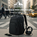 HighPeak Backpack With USB Charging in black on urban street showing external USB port charging phone and headphones plugged in