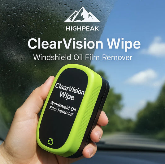 HighPeak ClearVision™ Windshield Oil Film Remover in green and black held against a car windshield outdoors.