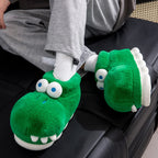 Close-up of crocodile slippers worn with white socks while relaxing on a black couch