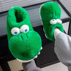 One green crocodile slipper held beside a matching slipper worn with white socks