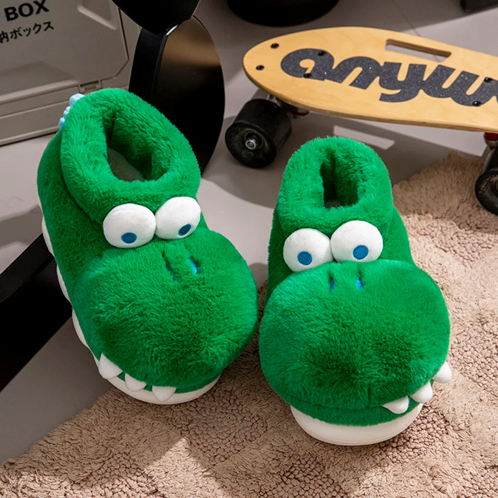 Overhead view of green crocodile slippers showing plush openings and cartoon faces