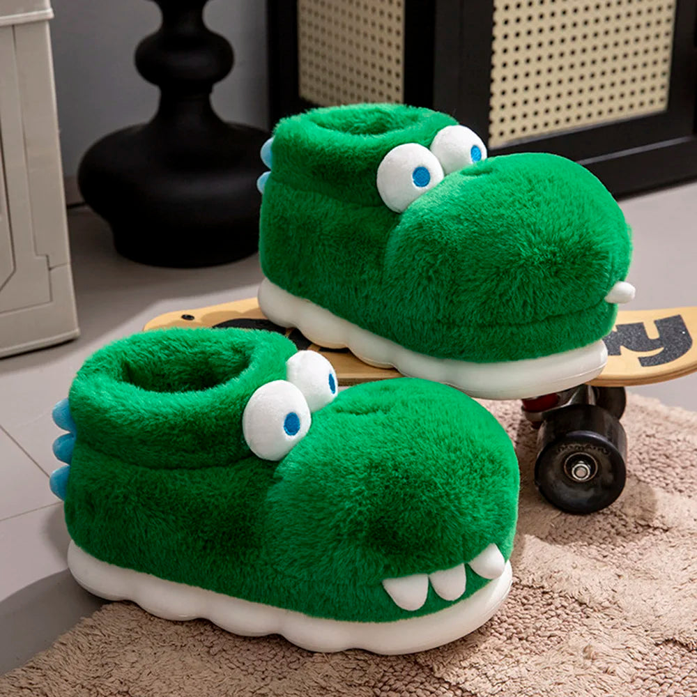 Three-quarter view of plush green crocodile slippers with white soles beside a skateboard