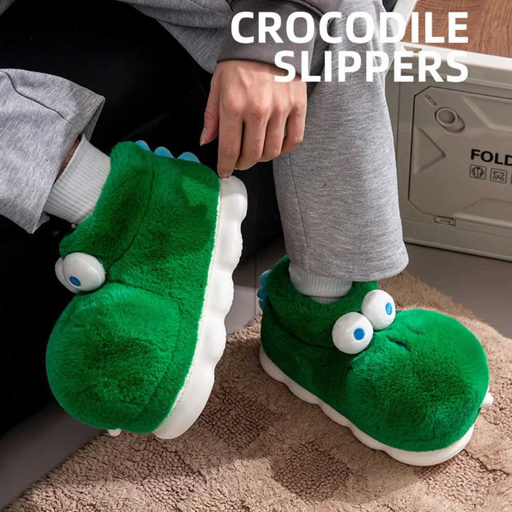 Person pulling on a green crocodile slipper while wearing gray lounge trousers