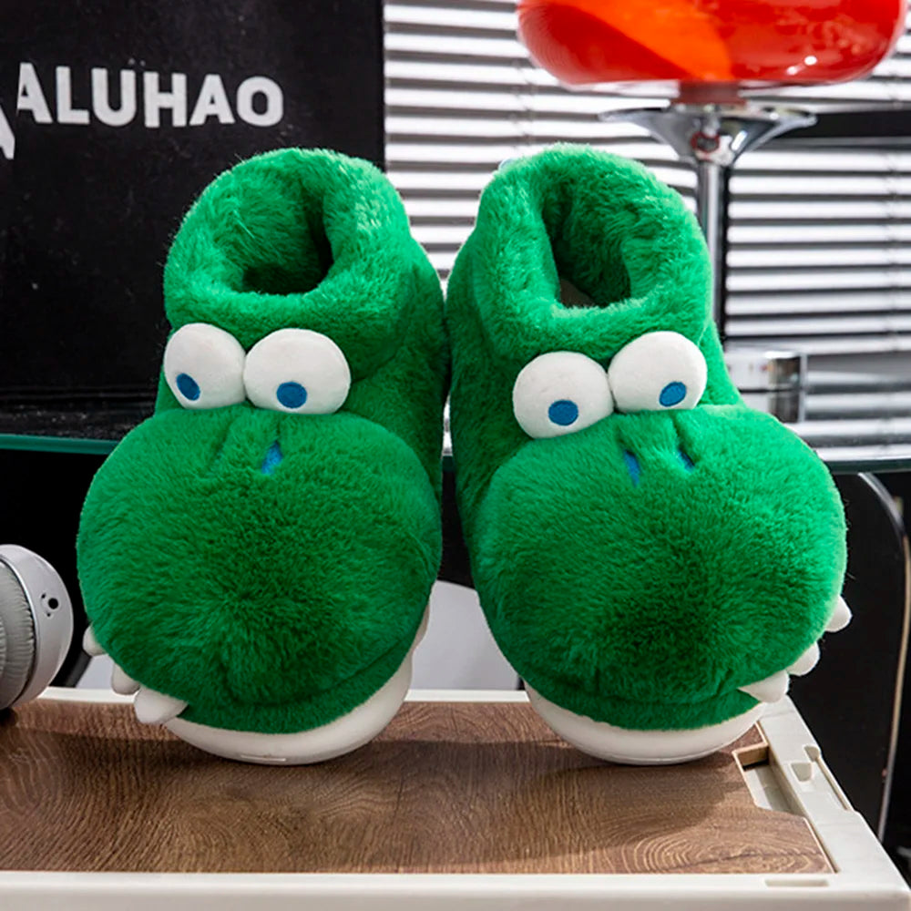 Front-facing crocodile slipper pair displayed on a wooden platform beneath a red stool