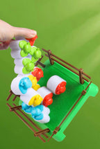 Hand lifting a chain of attached sheep above the game pen