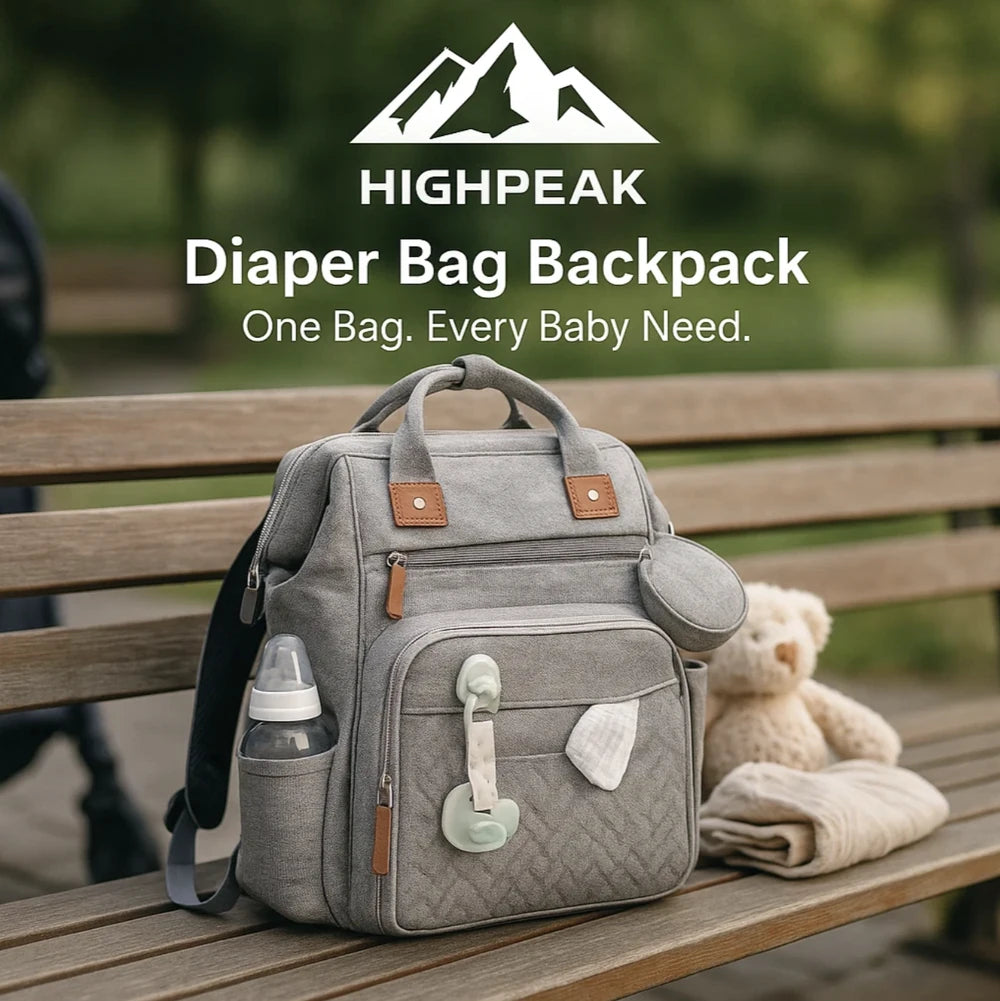 HighPeak Diaper Bag Backpack in grey with multiple compartments, bottle holder, and attached pacifier on a park bench