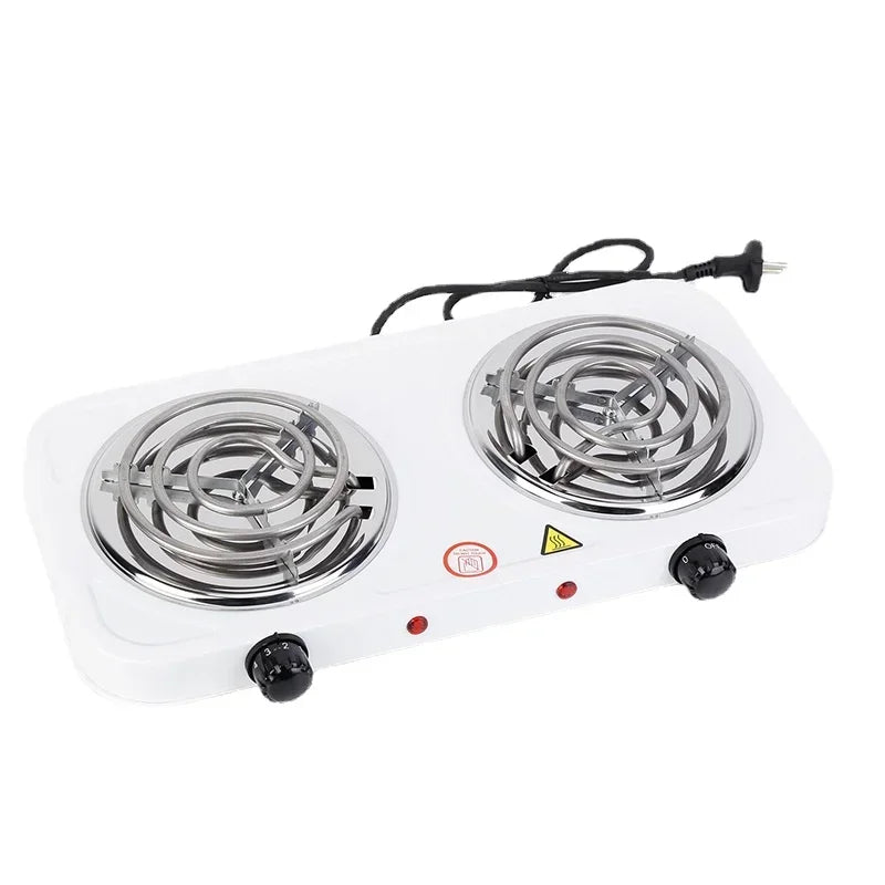 Angled view of white dual burner electric cooktop with silver coils, black control knobs and power cord