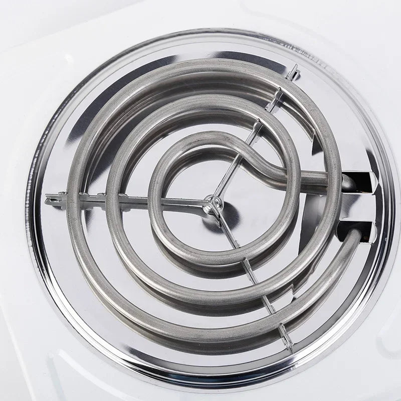 Close-up of the electric cooktop's spiral heating coil and metal burner support