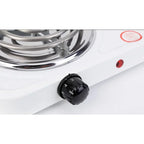 Close-up of numbered black heat control knob and red indicator light on the electric cooktop