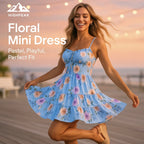 HighPeak Women's Floral Mini Dress in pastel blue with pink roses, spaghetti straps, worn outdoors at sunset by smiling model