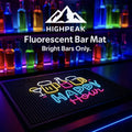 HighPeak Fluorescent Bar Mat with neon Happy Hour design on black rubber, glowing in a vibrant bar setting