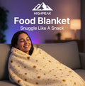 HighPeak Food Blanket burrito wrap design in beige on woman smiling and relaxing on gray couch indoors at night