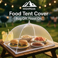 HighPeak Food Tent Cover in white mesh pop-up design protecting burgers and fruit on outdoor picnic table