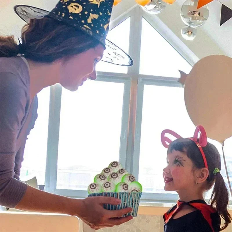 Adult in a witch hat offering a basket of Glowing Eyeball Bouncy Balls to a costumed child