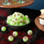 Glowing Eyeball Bouncy Balls in a bowl on a Halloween party table with black cloth