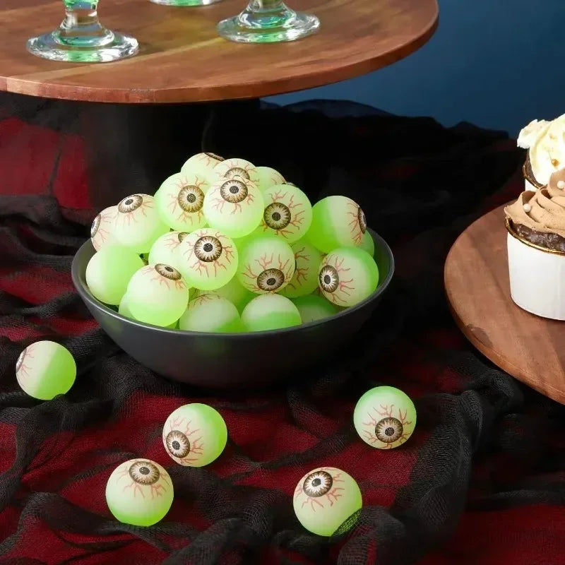 Glowing Eyeball Bouncy Balls in a bowl on a Halloween party table with black cloth