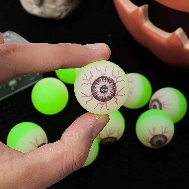 Hand holding a single Glowing Eyeball Bouncy Ball showing its iris and red vein print