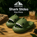 HighPeak Shark Slides in green with shark bite design on wooden deck near sunglasses and drink