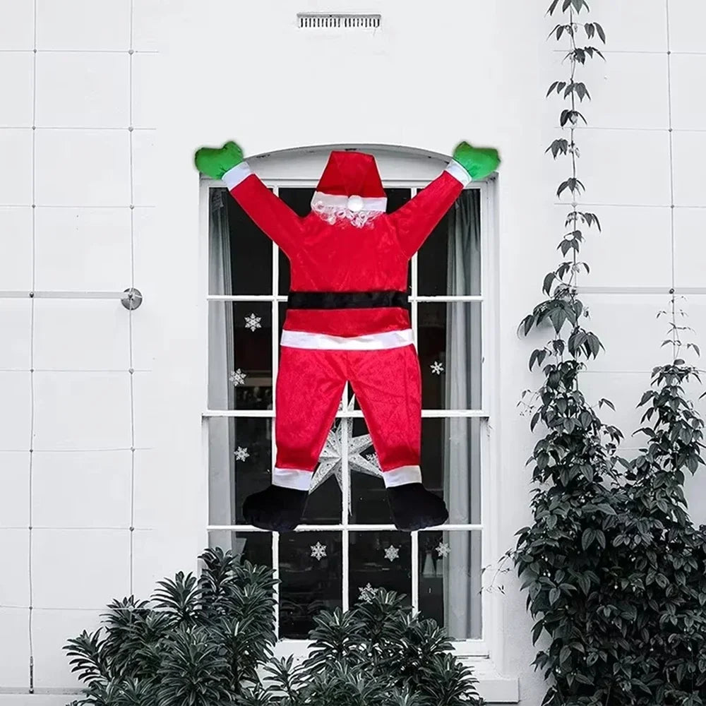 Red hanging Santa decoration with green mittens above an arched window on a white house.