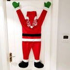 Back view of red hanging Santa decoration with curly white hair on a white door.