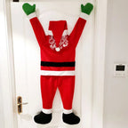 Hanging Santa Claus Decor with arms raised against a white indoor door.