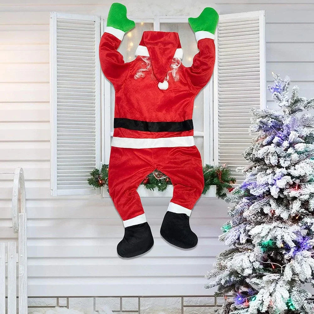 Red hanging Santa decoration with bent legs and green mittens at a festive shuttered window.