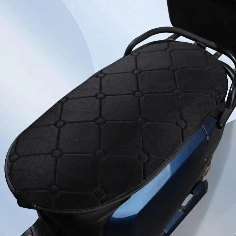 Close-up of the black quilted Heated Motorcycle Seat Pad on a blue scooter seat