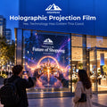HighPeak Holographic Window Projection Film displaying a colorful advertisement on a storefront window at dusk.