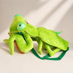 Green Mantis Plush Backpack reclining on a tabletop with folded front legs and stitched wings
