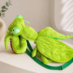 Green Mantis Plush Backpack resting on a shelf with stitched wings and a green zipper