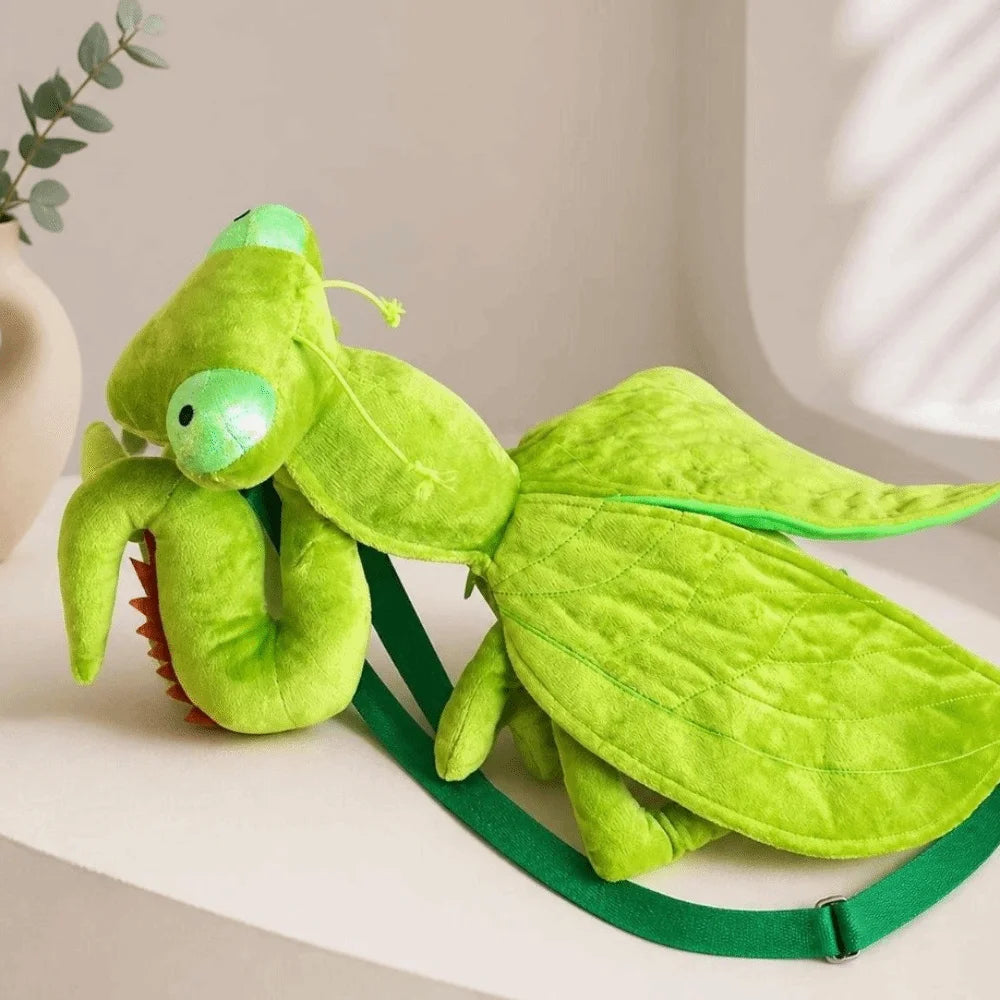 Green Mantis Plush Backpack resting on a shelf with stitched wings and a green zipper