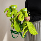 Person holding two green Mantis Plush Backpacks to show front and side details
