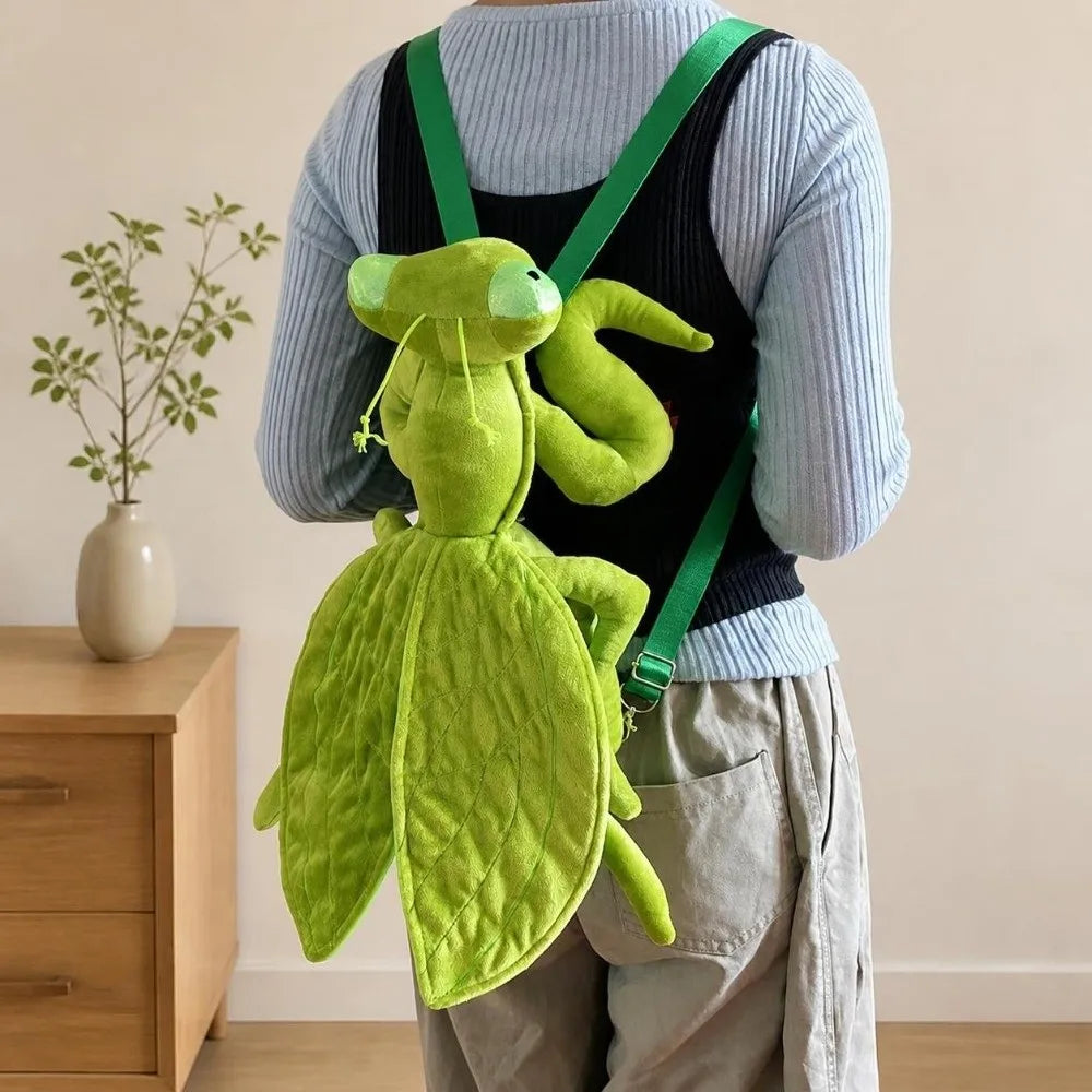 Green Mantis Plush Backpack worn over a gray sweater and black vest, viewed from behind