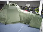 Indoor side view of the Multiroom Camping Tent showing the central dome, connecting tunnel and outer pod with flysheets fitted.