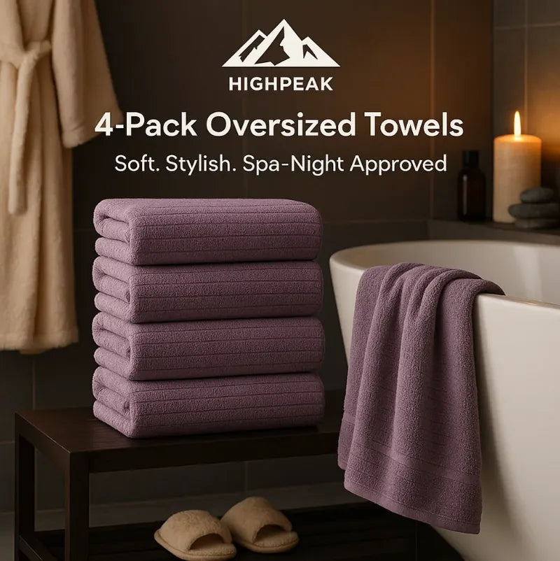 HighPeak 4-Pack Oversized Towels in purple stacked on shelf next to bathtub in cozy spa bathroom setting