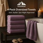 HighPeak 4-Pack Oversized Towels in mauve stacked and draped over tub in cozy spa-inspired bathroom setting