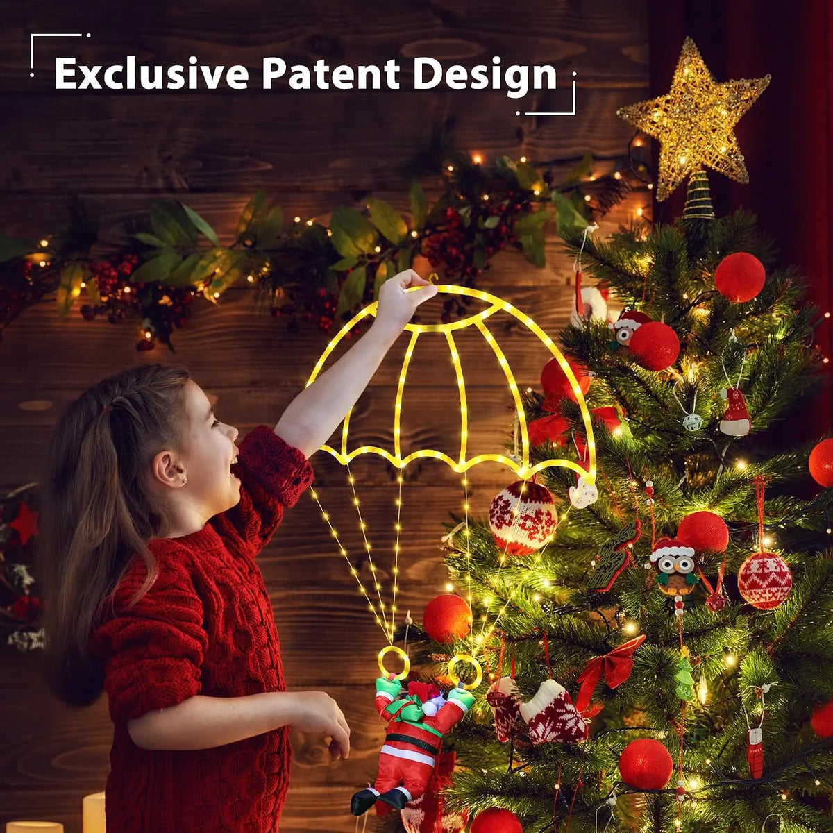 A person holding the warm white Parachuting Santa Lights beside a decorated Christmas tree.