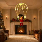 Warm white Parachuting Santa Lights hanging in a Christmas living room in front of a fireplace.