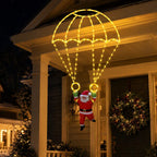 Warm white Parachuting Santa Lights illuminating a festive porch with Santa suspended below the parachute.