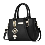 Pebbled Charm Shoulder Purse in black with rounded top handles, beaded charm and adjustable strap.