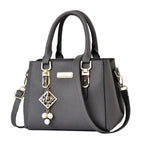 Pebbled Charm Shoulder Purse in dark grey with gold-tone hardware, dangling charm and top handles.