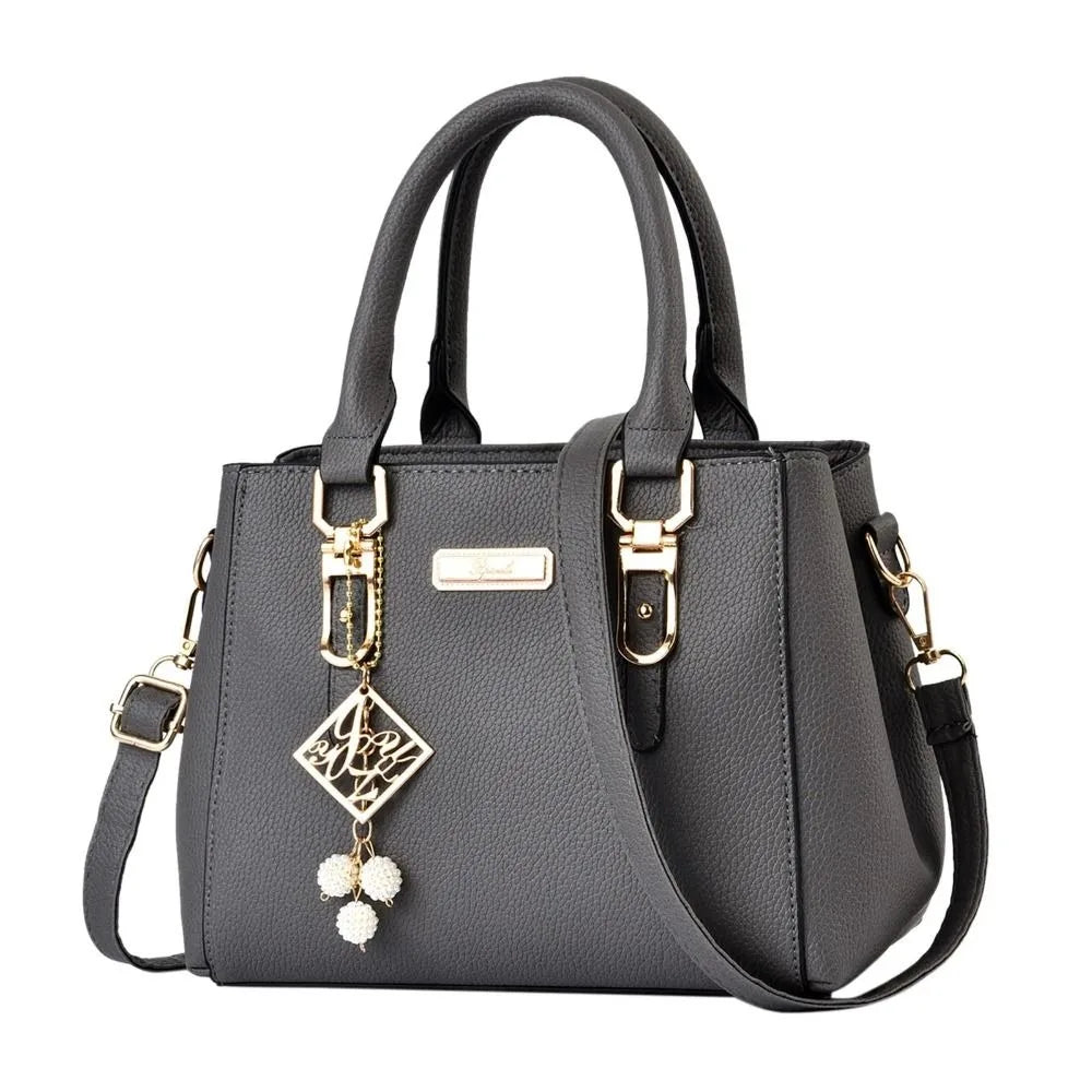 Pebbled Charm Shoulder Purse in dark grey with gold-tone hardware, dangling charm and top handles.