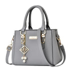 Pebbled Charm Shoulder Purse in grey showing pebbled texture, gold-tone hardware and shoulder strap.