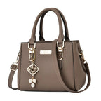 Pebbled Charm Shoulder Purse in khaki with top handles, adjustable strap and dangling beaded charm.