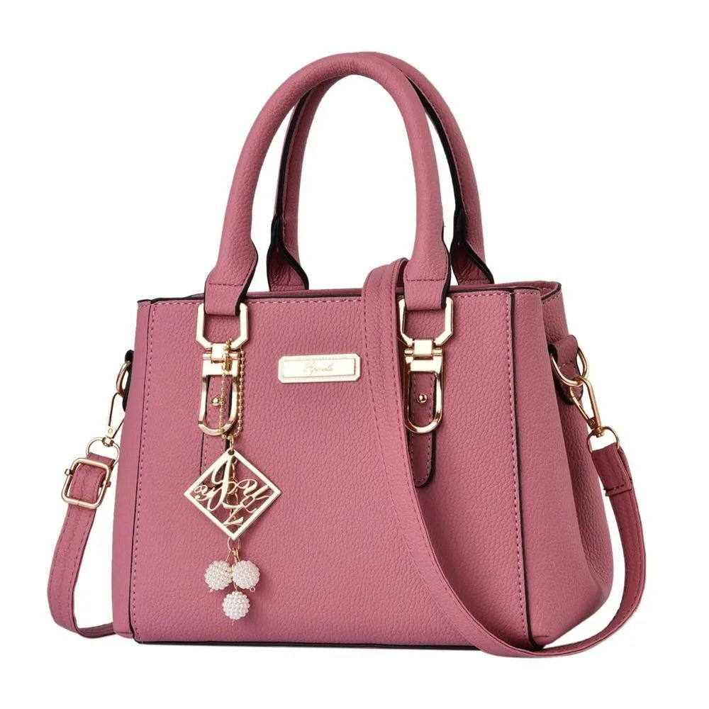 Pebbled Charm Shoulder Purse in pink with gold-tone fittings, adjustable strap and white beaded accents.