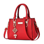 Pebbled Charm Shoulder Purse in red showing the pebbled finish, top handles and decorative charm.