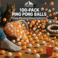 HighPeak 100-Pack Table Tennis Balls in orange and white scattered on wood floor with cat and red cup nearby