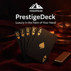 HighPeak PrestigeDeck playing cards in black with gold foil on red velvet near whiskey glass and lighter.